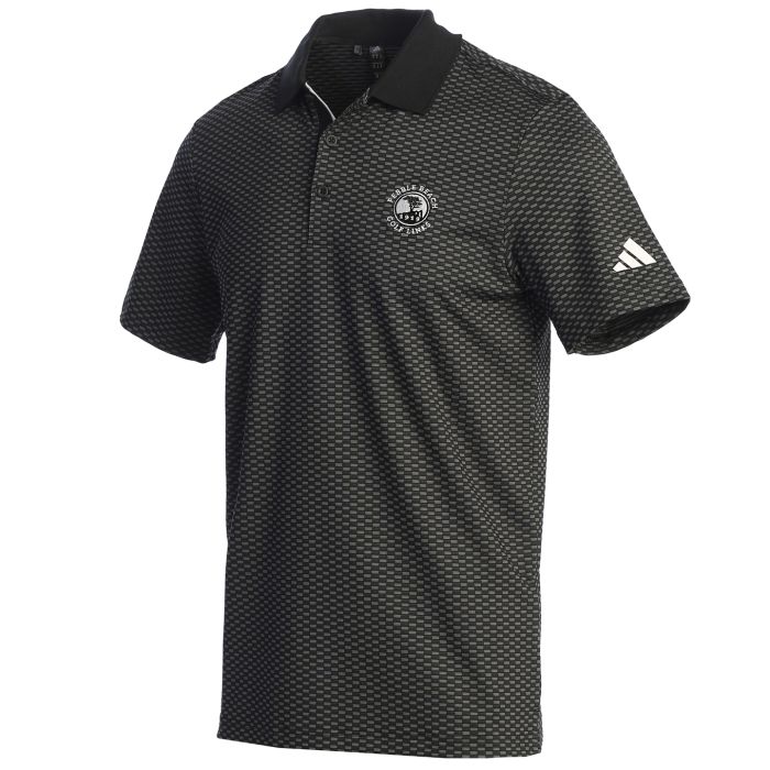 Black patterned polo shirt with Adidas logo on the sleeve and a Pebble Beach logo on the chest on a white background