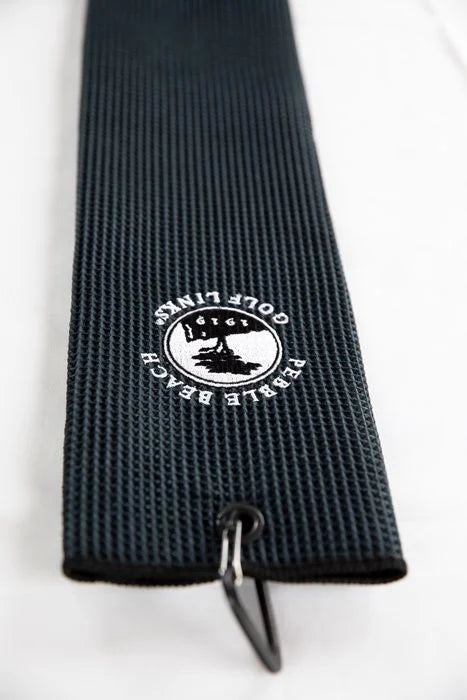 Black textured golf towel with a pebble beach logo and a hook on a white background