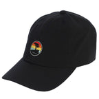 Black cap with a colorful sunset patch featuring a pebble beach logo on a white background