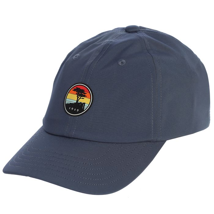 Blue cap with a colorful sunset patch featuring a pebble beach logo on a white background
