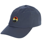 Blue cap with a colorful sunset patch featuring a pebble beach logo on a white background