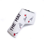 White blade putter golf club head cover with Cynthia the sea lion dancing holding a red flag and 'the hay' text on a white background