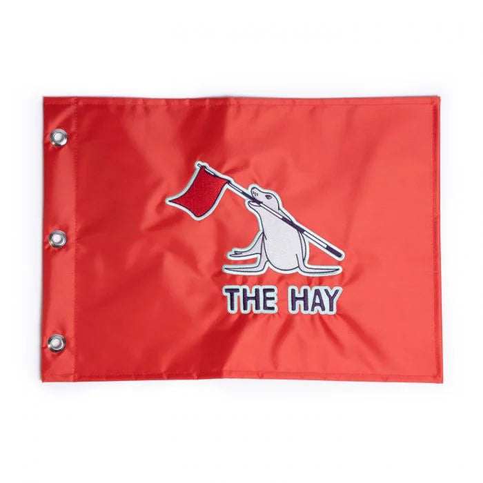 Red flag with 'The Hay' logo on a white background