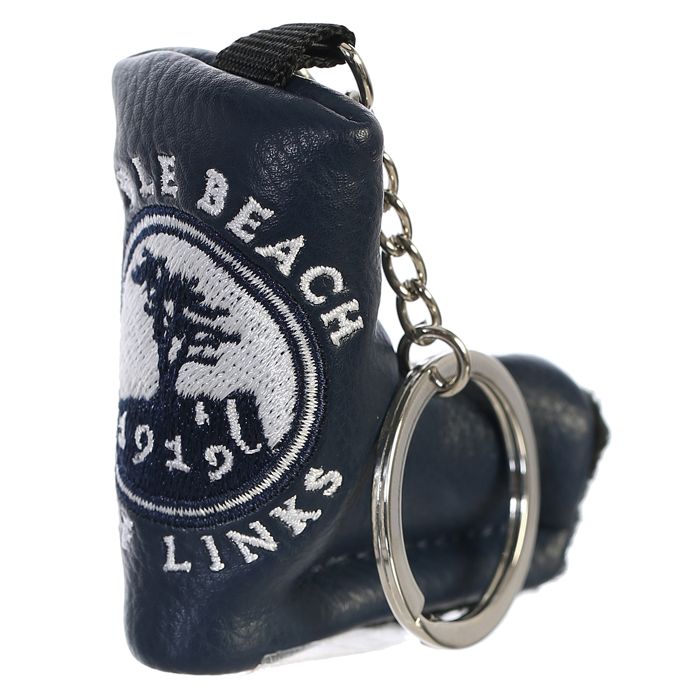 Navy blue golf club head cover keychain with embroidered pebble beach logo on a white background