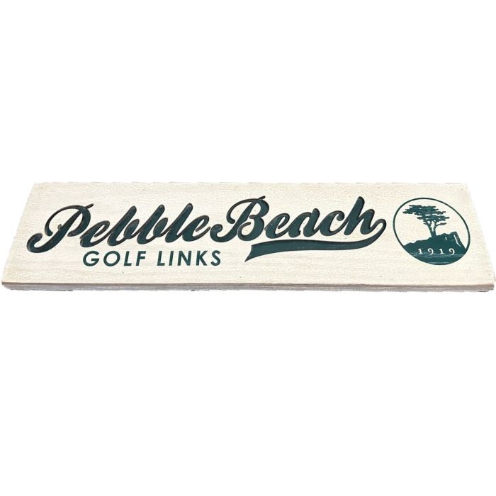 white wooden sign with 'Pebble Beach Golf Links' text in green on a white background.