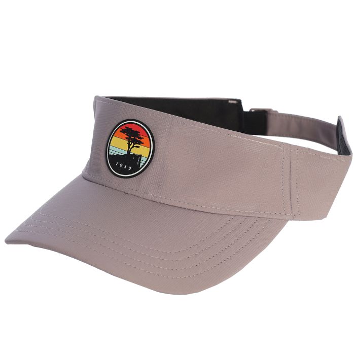 Grey visor with a colorful sunset patch featuring a pebble beach logo on a white background