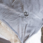 Gray blanket with 'Pebble Beach' logo on a white background
