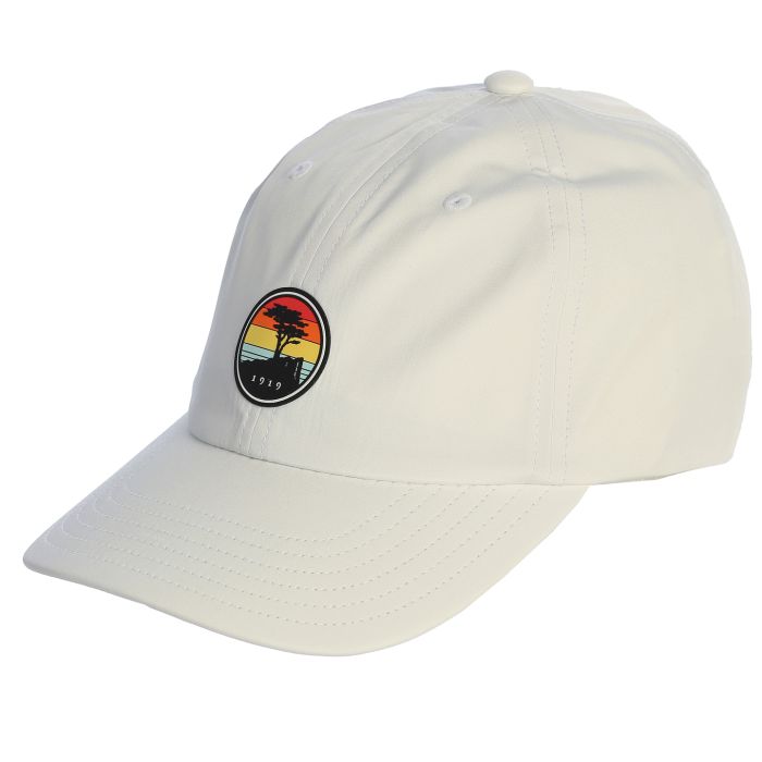White cap with a colorful sunset patch featuring a pebble beach logo on a white background